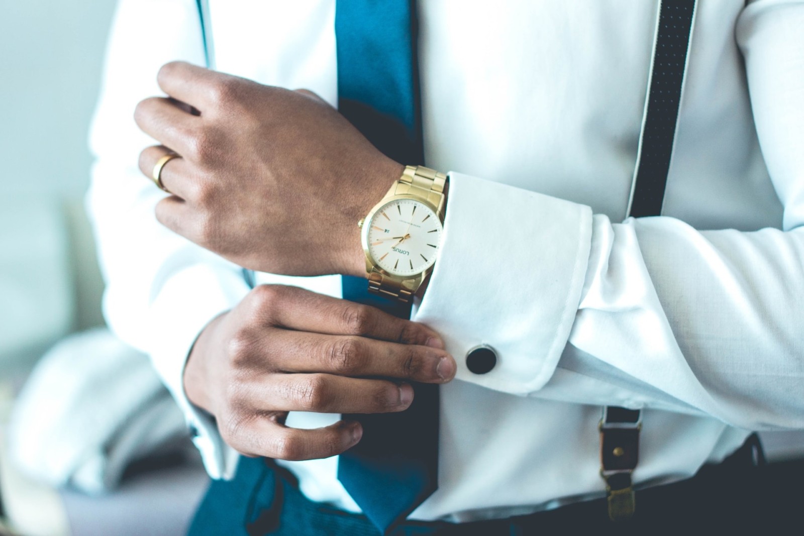 man gets ready with suit and watch for business meeting